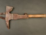 an old axe with a wooden handle on a gray surface