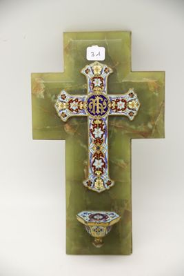 une croix accrochée au mur, sur laquelle repose un petit bol