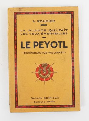un vieux livre à la couverture rouge et jaune posé sur une surface blanche