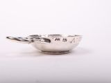 a close up of a silver bowl on a white surface