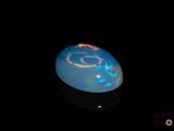 an image of a black opal in the dark