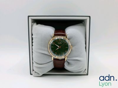 un gros plan d'une montre dans un coffret orné d'un nœud papillon