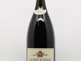 une bouteille de vin rouge avec une étiquette blanche posée sur une surface blanche