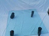 a glass table with four black candles on it