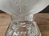 a close up of a glass bowl with a cross on it