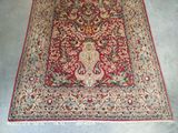 an oriental rug with a red background and a floral design