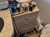 a desk with a computer and a trash can on it