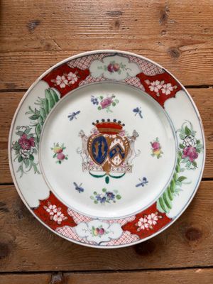 une assiette ornée d'un blason, posée sur une table en bois