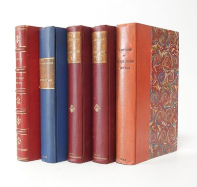 several old books are lined up in a row on a white surface