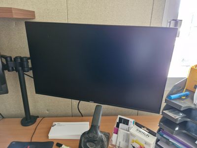 a computer monitor sitting on a desk next to a keyboard and headphones