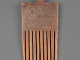 an old wooden comb with a design on the side of it