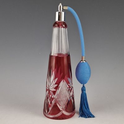 une bouteille en verre rouge avec une poignée bleue et une boule bleue