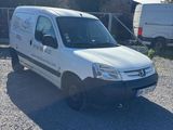 une camionnette blanche garée sur un parking en gravier