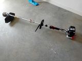 quelqu'un utilise une débroussailleuse pour tondre le sol d'une pièce