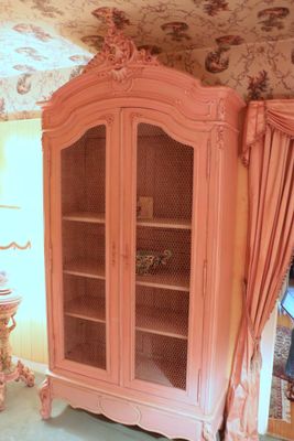 a pink cabinet in the corner of a room