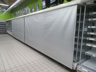 many empty shelves in a store that are covered with tarps