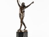 une statue en bronze représentant une femme tenant une raquette de tennis