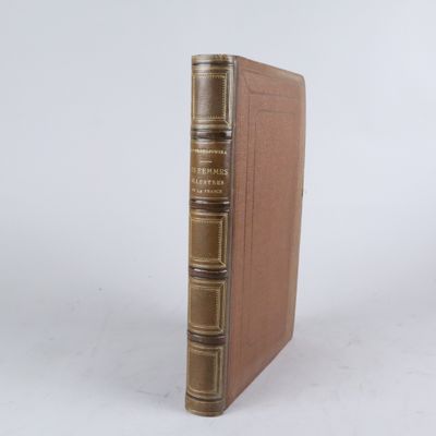 un vieux livre posé sur une table à côté d'un mur blanc