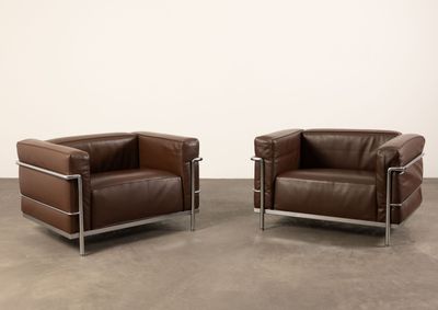 deux fauteuils en cuir marron placés l'un à côté de l'autre dans une pièce