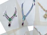 several different types of jewelry are displayed on a white surface