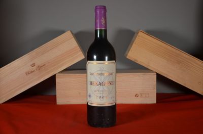 a bottle of wine sitting on a table next to two wooden boxes