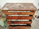 a wooden chest of drawers with a marble top
