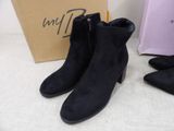 the black boots are next to a pink bag and a pair of shoes