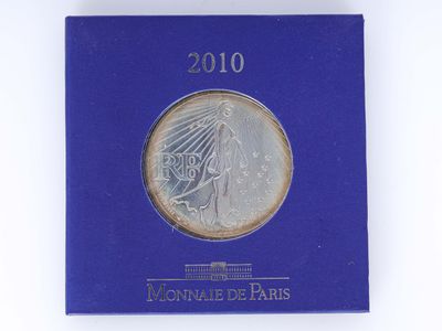 un gros plan sur un livre bleu sur lequel repose une pièce de monnaie