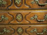 a wooden chest of drawers with brass handles on it