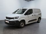 La camionnette blanche est garée dans une grande pièce d'un immeuble.
