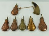plusieurs types de cloches en laiton disposées sur une surface blanche