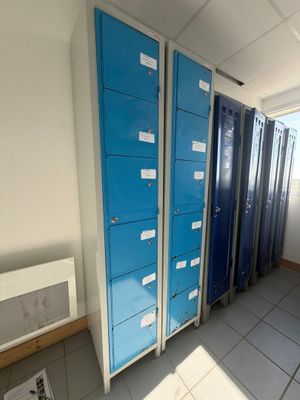 several blue lockers are lined up in a row in a room