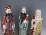 three chinese figurines of men with beards and hats