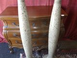 deux grands vases posés sur une table à côté d'une commode