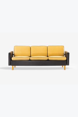 a black and yellow couch sitting on top of a white floor