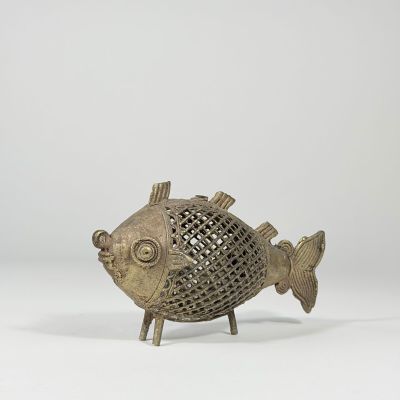 une figurine de poisson en bronze dont le corps et les pattes sont enfermés dans une cage