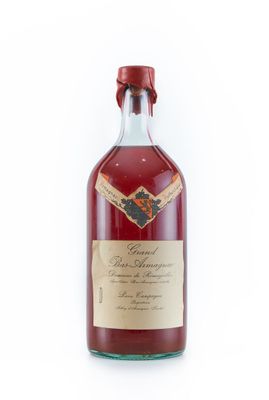 une bouteille de vin rouge posée sur une surface blanche
