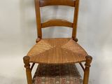 une image représentant une chaise en bois avec une assise et un dossier tressés