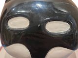 a black and white cat mask on a red and white plate