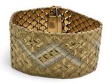gros plan d'un bracelet en or sur fond blanc