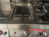 trois cuisinières en acier inoxydable dans une cuisine professionnelle