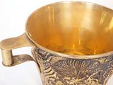 a gold cup with a handle on a white background