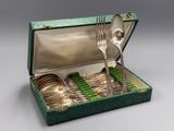 une boîte verte contenant des couverts, posée sur une table