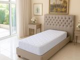 a bed in a room with a large window and a painting on the wall