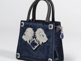 a blue handbag with a heart and two winged wings on it