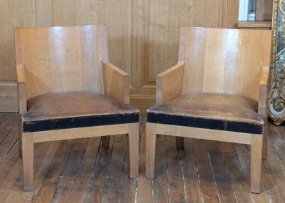 two wooden chairs that are sitting on a wooden floor