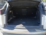 the back of a white car with its trunk open in a parking lot