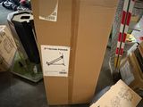 un grand carton posé par terre à côté d'une pile d'autres cartons