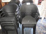 quatre chaises en osier noir posées sur un parquet