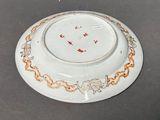 a white plate with gold and red designs on it